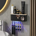 UV Sterilizing Toothbrush Holder in black with gold trim, a button, display and hanging toothbrush slots beneath a shelf