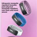 VIBE LOOP Ban Mosquito ultrasonic wristband in pink, blue, and white silicone, with black patterned face and small button.