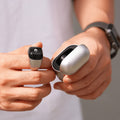 VIBE LOOP Ban smart fitness ring in silver alloy with a glossy black face beside its open silver charging case