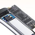 VIBE LOOP™ Multifunctional Smart Watch component with an exposed dark circuit board and silver battery inside a black casing