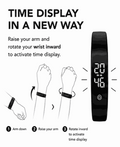 Vibration Loop Ban Alarm Watch in black with a slim band, showing a bright digital time display when the wrist rotates inward.