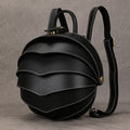 Vintage Genuine Leather backpack in black with a rounded beetle-inspired shape, layered curved panels, white stitching, and adjustable straps