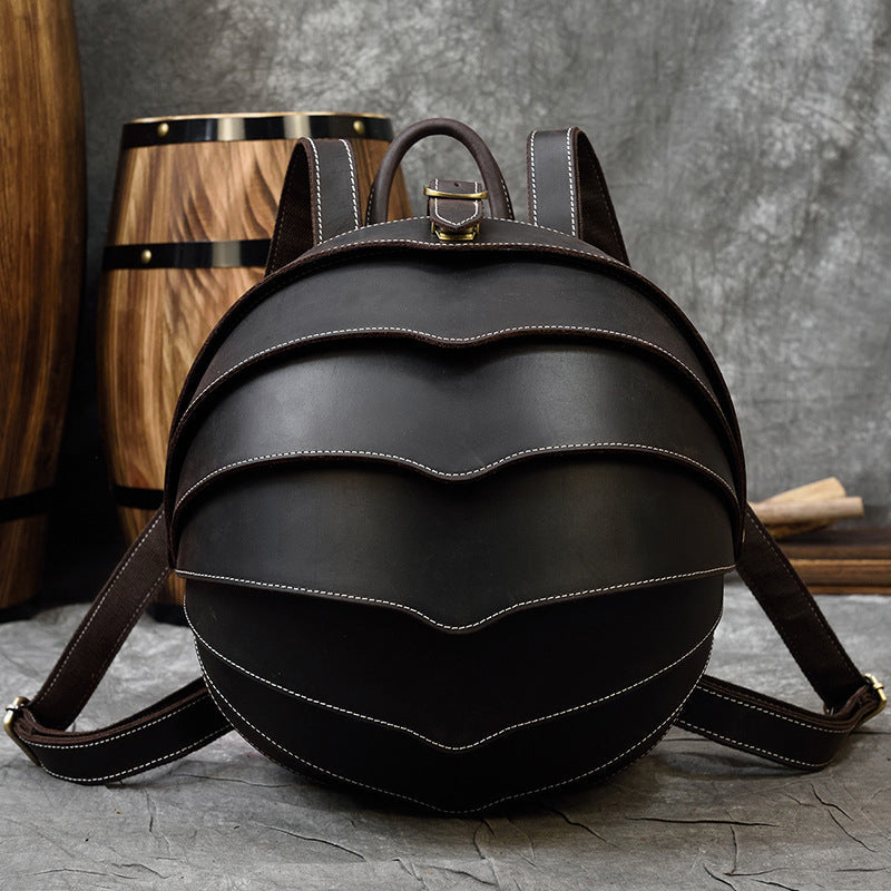 Vintage Genuine Leather backpack in dark brown with a rounded beetle-inspired shape, layered curved panels and contrast stitching