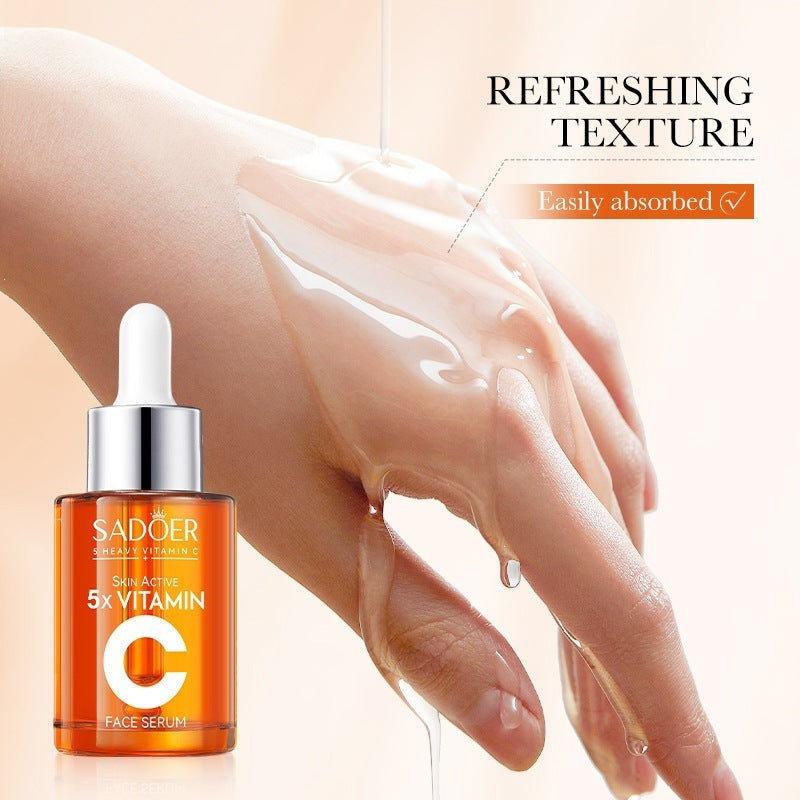 Vitamin C Multi-Function Repairing Essence Liquid in a clear glass dropper bottle filled with orange serum, labeled 5X Vitamin C face serum.