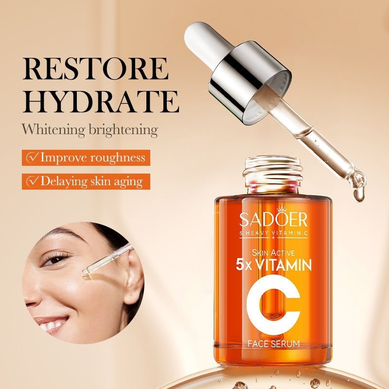 Vitamin C Multi-Function Repairing Essence Liquid in a clear glass dropper bottle filled with orange serum, labeled 5X Vitamin C face serum.