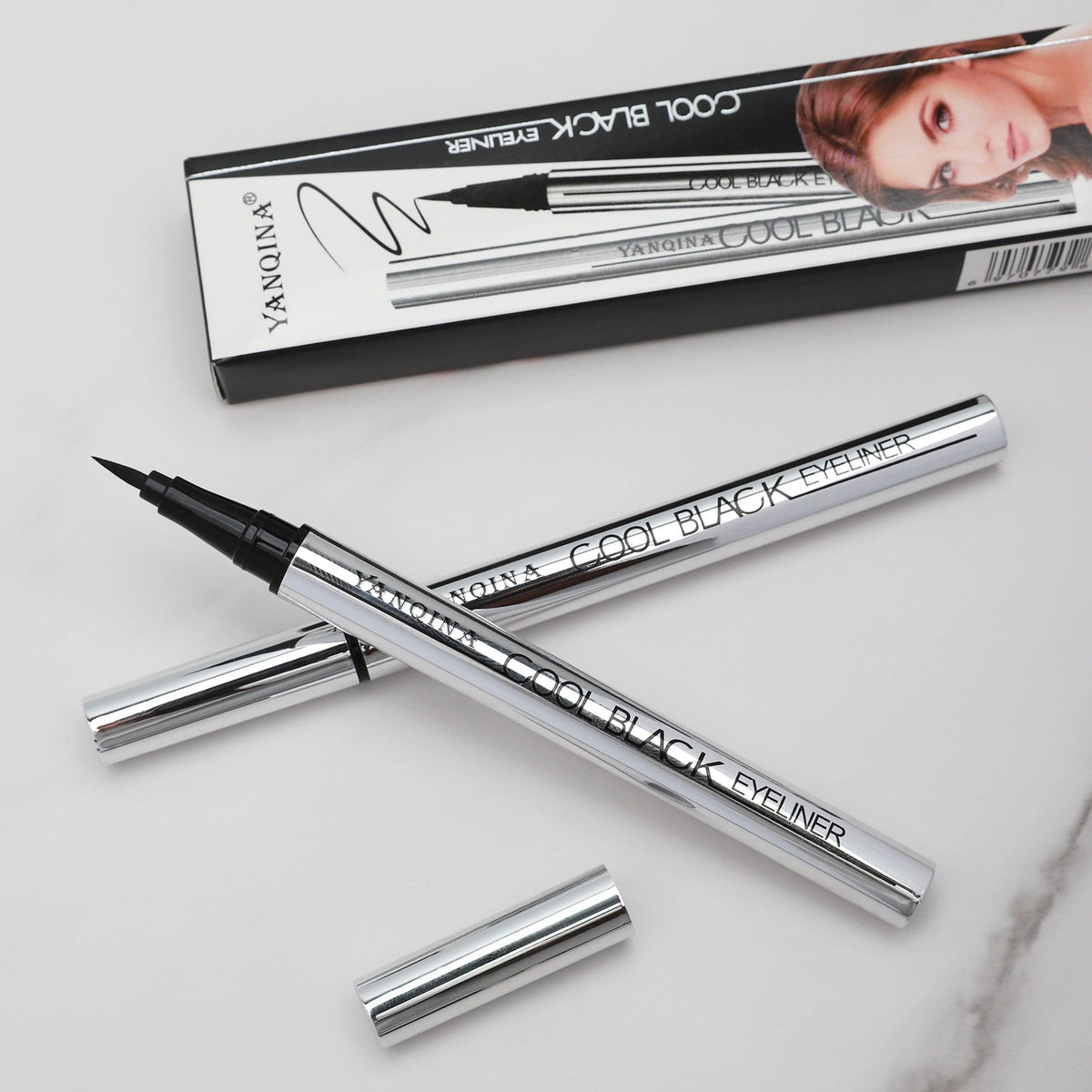 Waterproof Liquid Eyeliner Pen with a fine black felt tip and reflective silver barrel, shown with matching cap and box