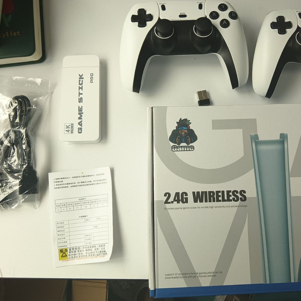 Wireless HDMI TV Game Console kit with white and black wireless controllers, white game stick, HDMI adapter and user manual.